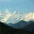 Pixelated landscape with light blue sky, white and gray clouds, and dark blue mountains under a bright light source.