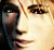 Pixelated close-up of a human face showing eyes, nose, and mouth with warm-toned skin tones against dark background.