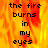 A pixelated image with fiery orange and yellow background displaying the text "the fire burns in my eyes" in black block letters.