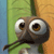 Pixelated cartoon character with large white eyes and brown pupils, holding a green leaf, against a green and blue background.