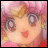 Pixelated anime-style character face with pink and orange background, featuring large eyes, a small red mouth, and visible facial features in low-resolution 256x256 format.