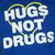 Static pixel art with white text 'HUGS NOT DRUGS' on a blue background, framed by a yellow heart outline.