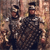 Two pixelated figures in dark uniforms with peaked caps stand side-by-side against a blurred background of warm brown and beige tones.