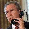 Static image of a man in business attire holding a vintage rotary telephone to his ear against a blurred background with vertical light patterns.
