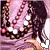 A pixelated image of a person with long dark hair wearing a pink top and beaded necklace, viewed from behind.