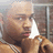 A pixelated static image shows a person with light skin tone holding a small dog, with a blurred background featuring a window and interior elements.