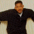 A pixelated image of a person in dark clothing with arms extended, next to green text reading 'Original Icons .com' on a solid background.