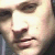 A static pixelated close-up of a person's face showing eyes, nose, and mouth with light skin tones and dark hair visible on the left side.