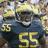 Pixelated image of a football player in a dark blue uniform with yellow number 55, helmet, and shoulder pads, next to yellow background with blue text Brandon Graham #55