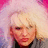 Pixelated image of a person with light-colored hair against a pink and purple gradient background.