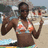 Pixelated image of a person in a bikini top on a beach with water and sand visible in the background.