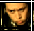 Pixelated close-up of a person's face with dark hair and earrings, framed by alternating black-and-gold borders in two adjacent