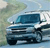 Pixelated image of a blue vehicle with white accents on a light background, showing front and side views.