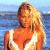 Pixelated static image of a woman with long blonde hair wearing a white bikini top against a blue water background.