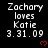 Black background displays repeated white text 'Zachary loves Katie 3.31.09' with red heart symbols, arranged in a pattern
