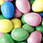 Pixelated image split into two sections: left shows colorful oval candies, right displays vertical pink text on cyan background.