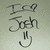 Pixelated grayscale image with stylized text 'I am John' and a hand gesture icon below, set against a light gray background.