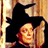 Static 48x48 pixel icon depicting a stylized witch character with black hat and red accents against warm-toned background.