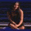 A woman with long dark hair in a black sleeveless top sits on a blue surface, her arms crossed and head turned right; another view shows her from the side.
