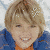 A pixelated image of a person with light brown hair wearing blue and orange clothing, displayed in two with text overlays