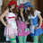 Three pixelated figures in a group pose: left figure wears red cap and white dress with red stripe, center figure has dark hair and pink top, right figure sports blue headwear and blue outfit.