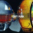 Pixelated static image shows two figures in a dynamic pose with one figure holding an object against a dark background.