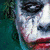 A split-screen image shows a character with white face paint, red lips, and dark eye makeup in two distinct poses against different backgrounds.