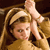 Pixelated image of a person with light brown hair wearing a headband, raising a hand in a gesture against a dark background.
