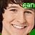 A pixelated close-up of a smiling person with brown hair, wearing a green headband displaying the text 'FAN' in white letters.