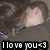 A pixelated image of a person with long brown hair wearing a dark gray shirt and blue-and-white striped collar, with text overlay reading "I love you<3".