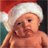 Pixelated image of a baby wearing a red and white Santa hat against a dark background with green and black elements.