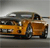 Pixelated image of a yellow and brown vehicle with dark windows and wheels, positioned on a gray background.
