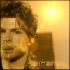 A static image of a person with tousled brown hair, warm lighting, and the text "Hot Up" in the bottom right corner.