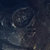 Pixelated dark blue background with faint light gray and white abstract shapes resembling blurred celestial bodies or nebulae.