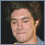 Pixelated image of a person with curly hair and a light blue shirt on the left, next to a black background with pixelated text reading 'PROUD AAA MEMBER' on the right.