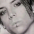 Pixelated grayscale image of a person's face with dark hair, visible eyes, nose, and mouth, and a neutral expression against a light background.