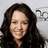 A static pixelated image of a person with long dark hair, closed eyes, and a slight smile against a light gray background.