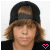 A 50x50 pixel animated buddy icon showing a person with brown hair and a black cap, featuring two frames where the bottom-right heart symbol changes color from pink to bright pink.