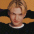 A pixelated image showing a person with light brown hair wearing a dark sweater over a white collar, next to green text reading "Original Icons .com" on a solid background.