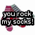Pixelated graphic with bold text "you rock my socks!" over a blurred background of pink and gray shapes.