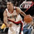 Pixelated image of a person in white athletic wear holding an orange basketball, with blurred background elements.