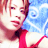 Pixelated static image of a person with light skin, red hair, and pink lips wearing a bright red top against a blue sky background.