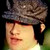 Static 50x50 pixel buddy icon showing a close-up of a person's face with dark hair and a flat cap, rendered in low-resolution pixel art style against a black background.