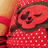 Pixelated red character with closed eyes, dark hair, and white polka dots on a red dress against an orange background.