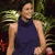 A pixelated image of a person in a dark sleeveless top with light skin, standing against green foliage background.