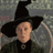 Static 48x48 pixel icon of a character in dark clothing with a large black hat, set against a gray stone background.