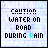 Static image of 'CAUTION WATER IN ROAD DURING RAIN' text with varying blue coloration on a light background.