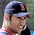 Pixelated image of a person wearing a dark baseball cap with red 'B' logo, standing beside green background text reading Original Icons .com.