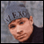 Pixelated static image of a person's face with visible facial features and partial background elements, rendered in low resolution.