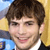 Static 50x50 pixel icon showing a close-up of a person with brown hair, light skin tone, and visible facial features including eyes, nose, mouth, and ear, wearing dark clothing with white collar against blurred background.